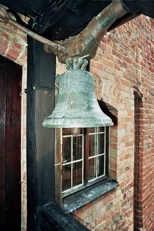 Zabytkowy dzwon na drewnianym ganku