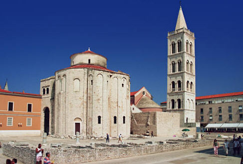 Dwa stare kościoły w otoczeniu resztek rzymskich. Kościół św. Donata z IX w. (rotunda) i kościół św. Anastazji z XII w. (z wieżą)