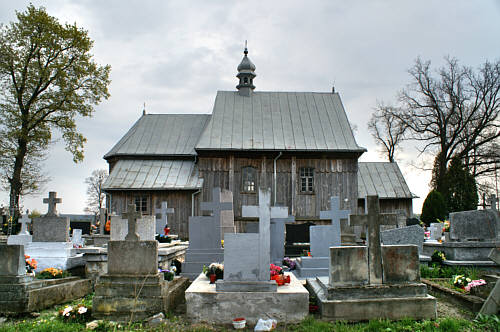 Zdjęcie przedstawia kościół w otoczeniu cmentarza