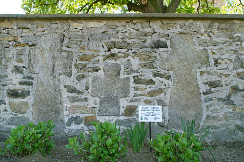 Trzy średniowieczne krzyże pokutne w murze okalającym kościół